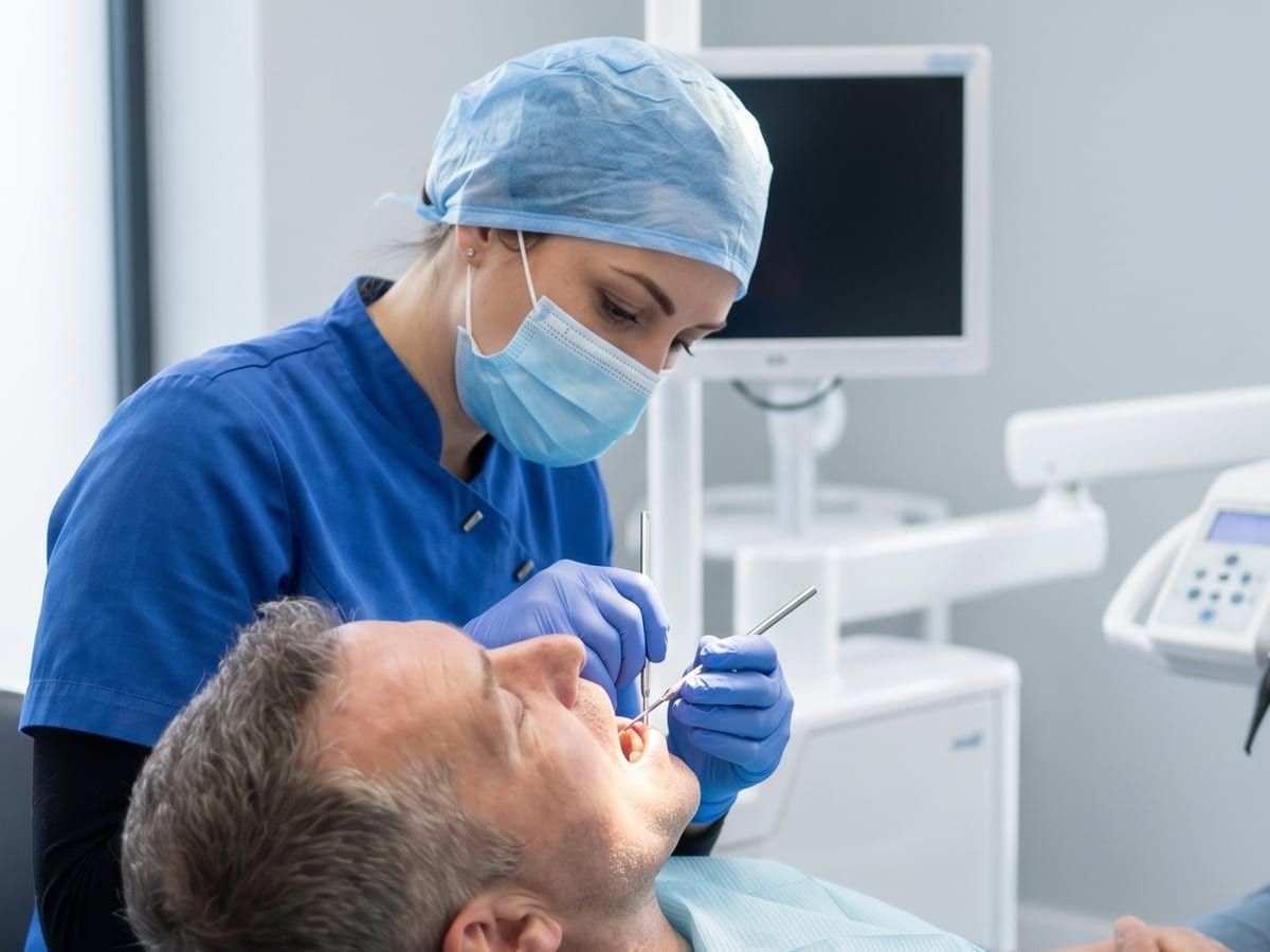 A dentist fitting veneers for a patient in clinic